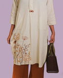 Woman wearing cream embroidered long kurta with floral motif paired with brown straight pants  Soft, breathable fabric ideal for daily and office wear, Lightweight, easy-to-style ethnic wear set with premium finish - elegant ethnic wear by Indu Heritage